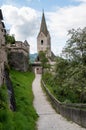 A tall church tower with a clock and an access path and wall defenses at the old Hochosterwitz Castle in Carinthia, Austria. Royalty Free Stock Photo