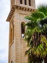 Old church clocktower with a big palm tree in front of it, Crete, Greece Royalty Free Stock Photo