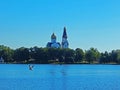 An old church near the lake with a seagull flying by