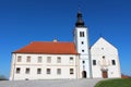 Old church with partially restored outer facade on top of small hill with large paved driveway surrounded with grass and clear Royalty Free Stock Photo