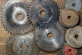 Old circular saw blades and emery wheels on wooden table, closeup, top view. Carpentry tools, sawing and grinding equipment Royalty Free Stock Photo