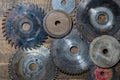 Old circular saw blades and emery wheels on wooden table, closeup, top view. Carpentry tools, sawing and grinding equipment Royalty Free Stock Photo