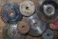 Old circular saw blades and emery wheels on wooden table, closeup, top view. Carpentry tools, sawing and grinding equipment Royalty Free Stock Photo