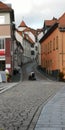 The old city center in Germany,cobbled streets on cloudy autumn day. In the distance elderly man rides in wheelchair Royalty Free Stock Photo