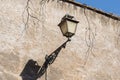 Old city lantern on the wall. Vintage iron lantern, outdoor garden street wall metal electrical lamp in town or village Royalty Free Stock Photo