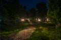 Old city park at night with a paving stone, greenery and lanterns Royalty Free Stock Photo