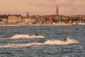 Old city by the sea with two watercrafts in the foreground Royalty Free Stock Photo