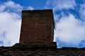 Old clay brick chimney looking weathered and rugged. Royalty Free Stock Photo