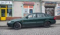 Old classic dark green sedan car Mazda 626 parked