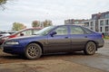 Old classic dirty sedan car Mazda 626 parked