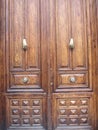 Old, classic and large wooden door with two metal hands used to knock on the door Royalty Free Stock Photo