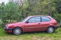 Old classic purple red Toyota Corolla hatchback car two doors
