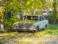 Old classic russian broken car under tree, out off road. Yekaterinburg, Russia