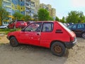 Old classic rusty small compact car Peugeot 205 left side rear view from eighties parked