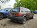 Old classic rusty small compact car Toyota Corolla from eighties parked