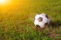 Old and classic soccer ball or soccer ball on a green field, sunset light Royalty Free Stock Photo