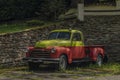 Old classic veteran car with silver red yellow colors and stone wall