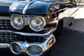 An old classic vintage retro automobile with big headlamps, front grill, and lights