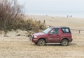 Old classic 4WD car Suzuki Vitara driving on a beach Royalty Free Stock Photo