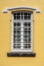 An old classic yellow stucco painted house wall with windows. Calssic buildings and windows textures.