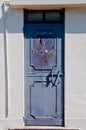 Old classical vintage metal blue European door of white apartment in sunny day