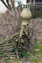 Old clay broken pitcher hanging on a wicker fence Royalty Free Stock Photo