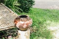 Old clay pot stands on a birch stump. Clay jug on the table Thai style Asian garden Royalty Free Stock Photo