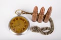 Old clock and ammunition on a white table. Explosive material and time measure