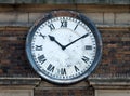 Old clock on the brick wall of a building with roman numerals with hands at ten past ten Royalty Free Stock Photo