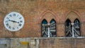 Old clock on exterior brick wall of Santa Maria della Scala, Siena Royalty Free Stock Photo