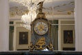 Old clock on the fireplace in front of the mirror