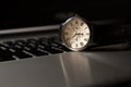An old clock and a laptop , the clock is on the laptop keyboard. Watch on table Royalty Free Stock Photo