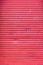 A old closed broken red roller shutter