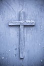 Old closed church doorway with small wooden religious cross