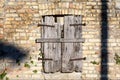 Old closed window with wooden balconies on facade of old brick and stone wall. Royalty Free Stock Photo