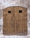 Old closed wooden door. Arch in the stone wall Royalty Free Stock Photo