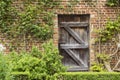 Old Closed Wooden Door in a Brick Wall in a Garden Royalty Free Stock Photo