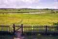 Old closed wooden gate with a fence in summer Sunny day Royalty Free Stock Photo