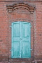 Old closed wooden shutters on window of red brick house. Royalty Free Stock Photo