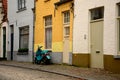 Old cobbled street, yellow wall and green scooter