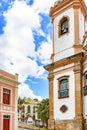 Old cobblestone street with houses and church in colonial architecture Royalty Free Stock Photo