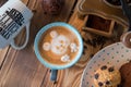 Old coffee grinder and coffee cup with scattered coffee beans and cookies on wooden background Royalty Free Stock Photo