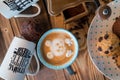 Old coffee grinder and coffee cup with scattered coffee beans and cookies on wooden background Royalty Free Stock Photo