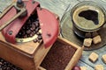 Old coffee grinder with a cup of coffee.