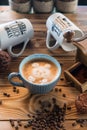 Old coffee grinder and coffee cup with scattered coffee beans and cookies on wooden background Royalty Free Stock Photo