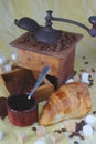 Old coffee grinder, cup, spoon and sugars. Croissant Royalty Free Stock Photo