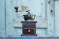 Old coffee grinder on a light blue wooden background. Front view Royalty Free Stock Photo