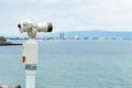 Old touristic telescope with blurred city and sea landscape background Royalty Free Stock Photo