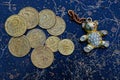 Old coins on the table and teddy bear keychain Royalty Free Stock Photo