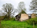 Old and collapsed country house, collapsed wall and old wooden logs